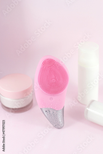 Pink brush facial skin care with cosmetic bottles