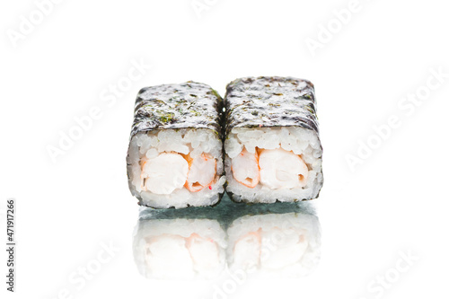 Two pieces of Japanese Ebi Maki sushi roll with nori seaweed on top. Shrimp inside roll. Side view of inside out roll isolated on white background. Copy space menu image with reflection 