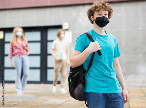 Portrait of teenager boy in protective mask going to school lessons on sunny summer day
