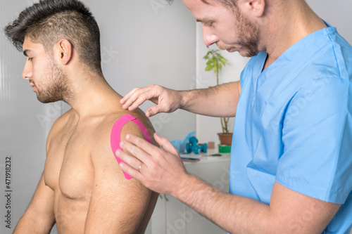 Physical therapist applying kinesio tape on male patient knee. Kinesiology, physical therapy, rehabilitation concept. close up. High quality photo photo