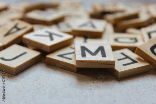 Small wooden letters, scattered on a light background