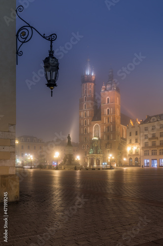 Main market square, Cloth Hall and St Mary's church in the misty night, Krakow, Poland