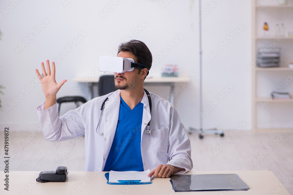 Young male doctor wearing virtual glasses in the clinic Young male doctor wearing virtual glasses in the clinic