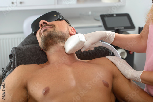 Laser hair removal on mans neck. man in a goggles.