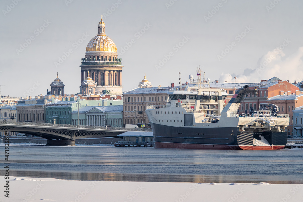 The panoramic view of the winter city Saint-Petersburg, big ship moored near Blagoveshchensky bridge, Isaac cathedral on background