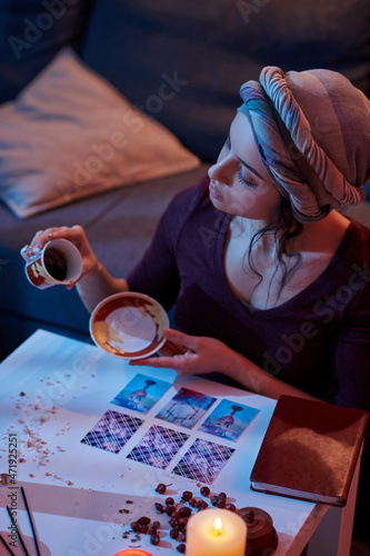 Focused fortune-teller starting the coffee reading procedure photo