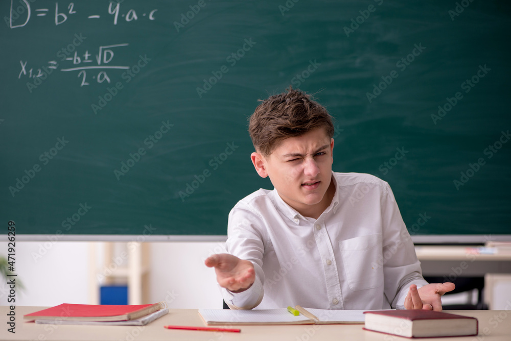 Schoolboy studying math in front of blackboard Schoolboy studying math in front of blackboard