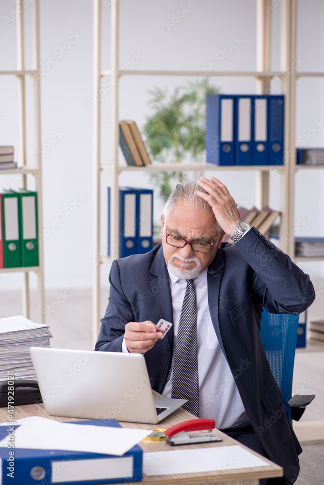 Old male employee feeling bad at workplace Old male employee feeling bad at workplace