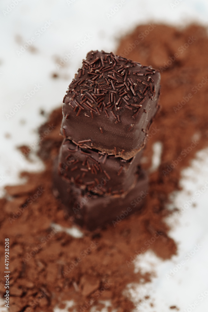 Dark Chocolate Petit Four Cakes Stack on Cocoa and Sprinkles Vertical, Valentine's Day Dessert Dark Chocolate Petit Four Cakes Stack on Cocoa and Sprinkles Vertical, Valentine's Day Dessert