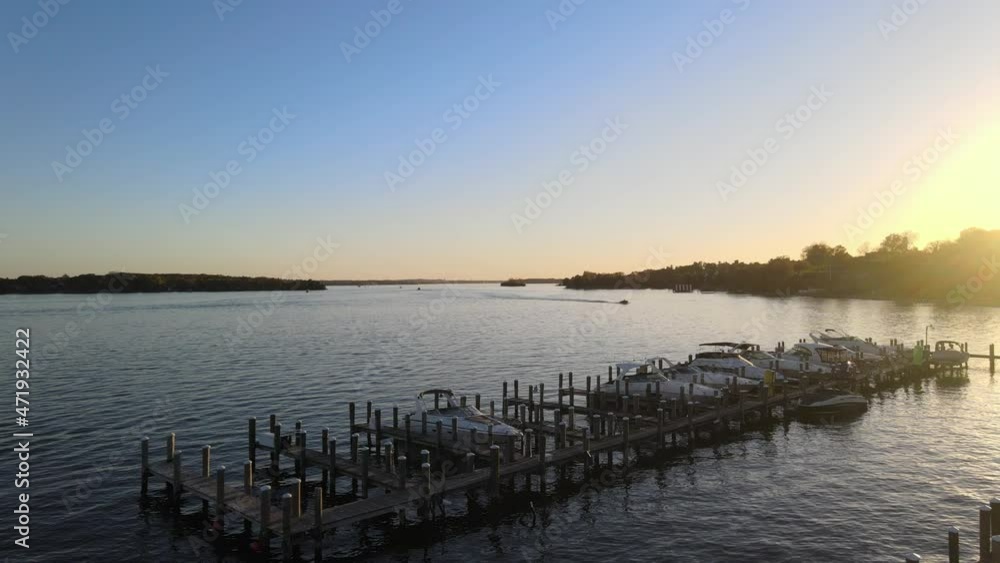sun setting over the horizon with a boat sailing at Lake Minnetonka, cinematic aerial view sun setting over the horizon with a boat sailing at Lake Minnetonka, cinematic aerial view