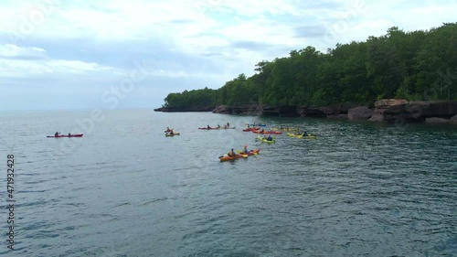 Group of kayakers exploring the apostles island in Lake Superior Wisconsin, Madeline Island during summer. Summer activities visit WI photo