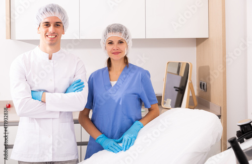 Portrait of young confident man and woman doctors in interior of clinic of aesthetic medicine