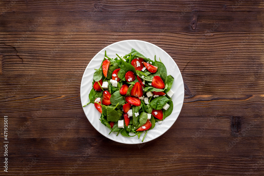Spinach salad with strawberry and goat cheese, top view Spinach salad with strawberry and goat cheese, top view