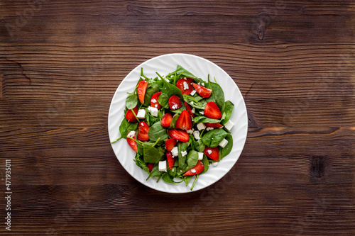 Spinach salad with strawberry and goat cheese, top view