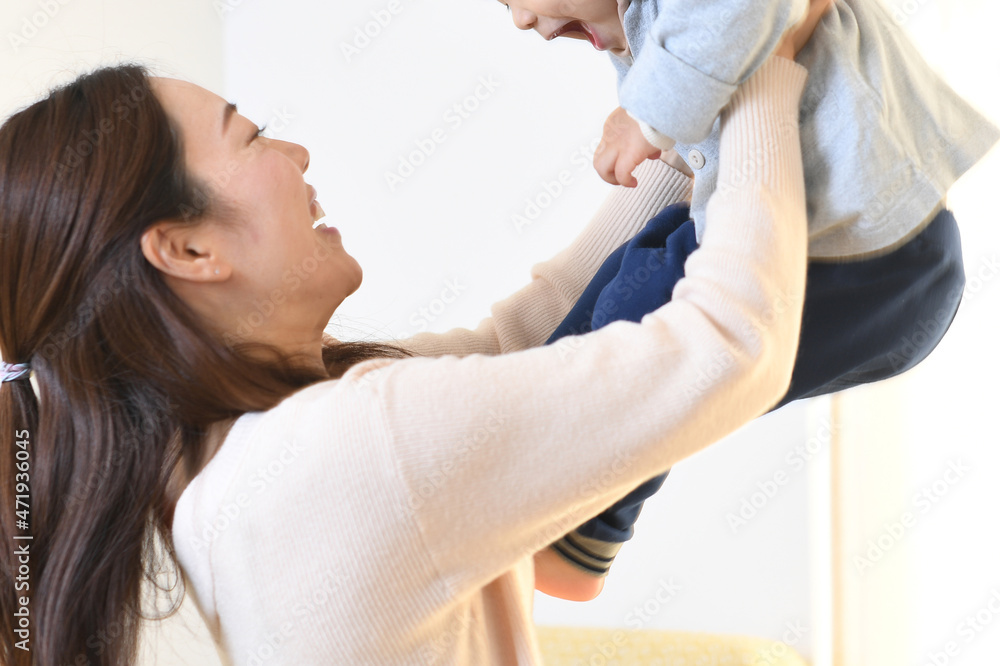 Obraz premium 抱っこ（高い高い）をする母と息子（親子）のイメージ