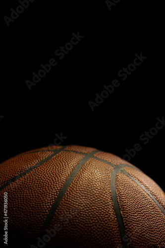 Detail of orange basketball ball with black background. Studio shot with basketball ball isolated.