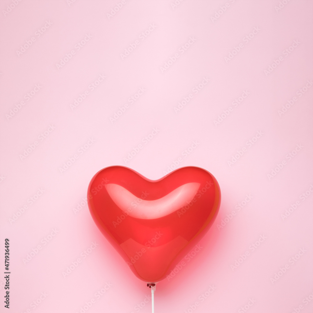 A heart-shaped balloon on a pink background. Space for text.