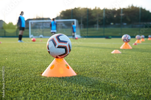 UK, Soccer balls on cones in field photo