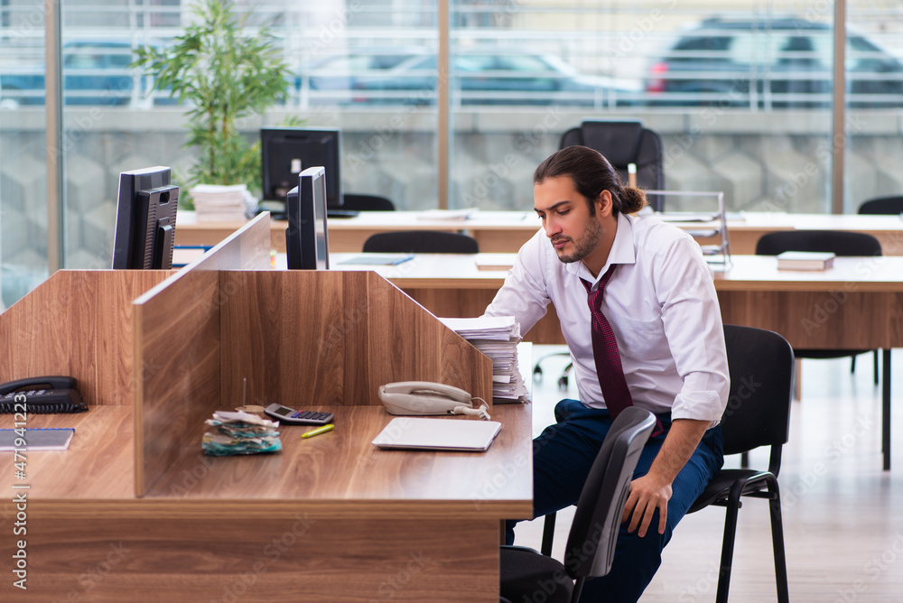Young male employee and too many work in the office Young male employee and too many work in the office
