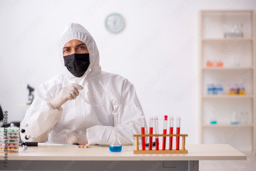 Young male chemist in drugs synthesis concept Young male chemist in drugs synthesis concept