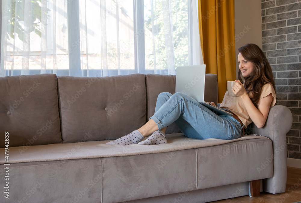 Obraz premium A woman is smiling while talking with someone remotely. Girl working from home
