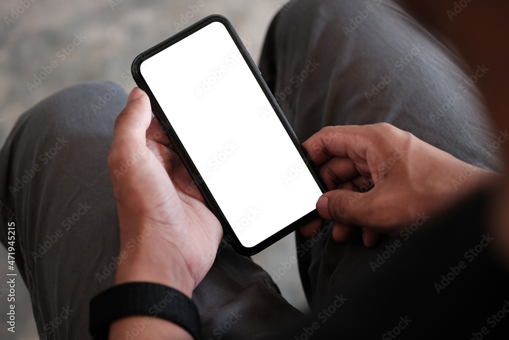 Close up view casual man sitting in living room and using smart phone.. Close up view casual man sitting in living room and using smart phone..