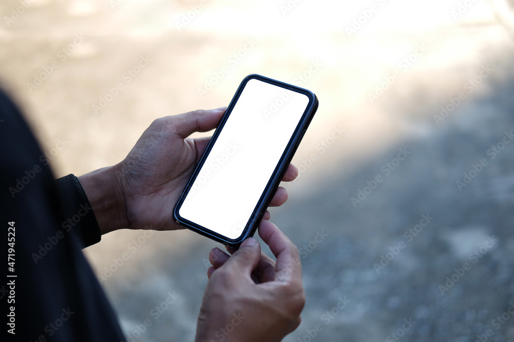 Close up view man holding mock up mobile phone with blank screen..