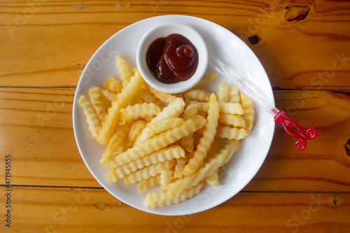 French fries serve on white dish with ketchap. photo