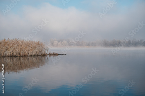 Autumn morning landscape. Sunrise over the lake in fog. The beginning of winter  the roe on the trees and grass.