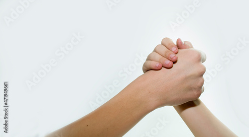 A child's hand fights with an adult hand on a white background, a concept for equality.