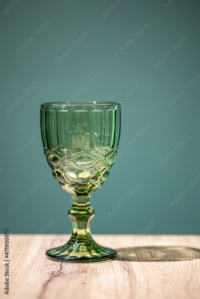 Glass green textured goblet on a blue background. Glass green textured goblet on a blue background.