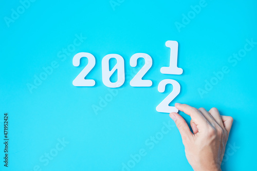 hand change 2021 to 2022 number on blue background. Plan, finance, Resolution, strategy, solution, goal, business and New Year holiday concepts
