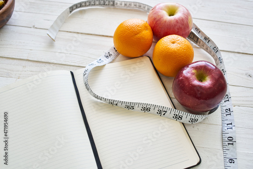notepad on table measuring tape fruit breakfast nutritional fitness