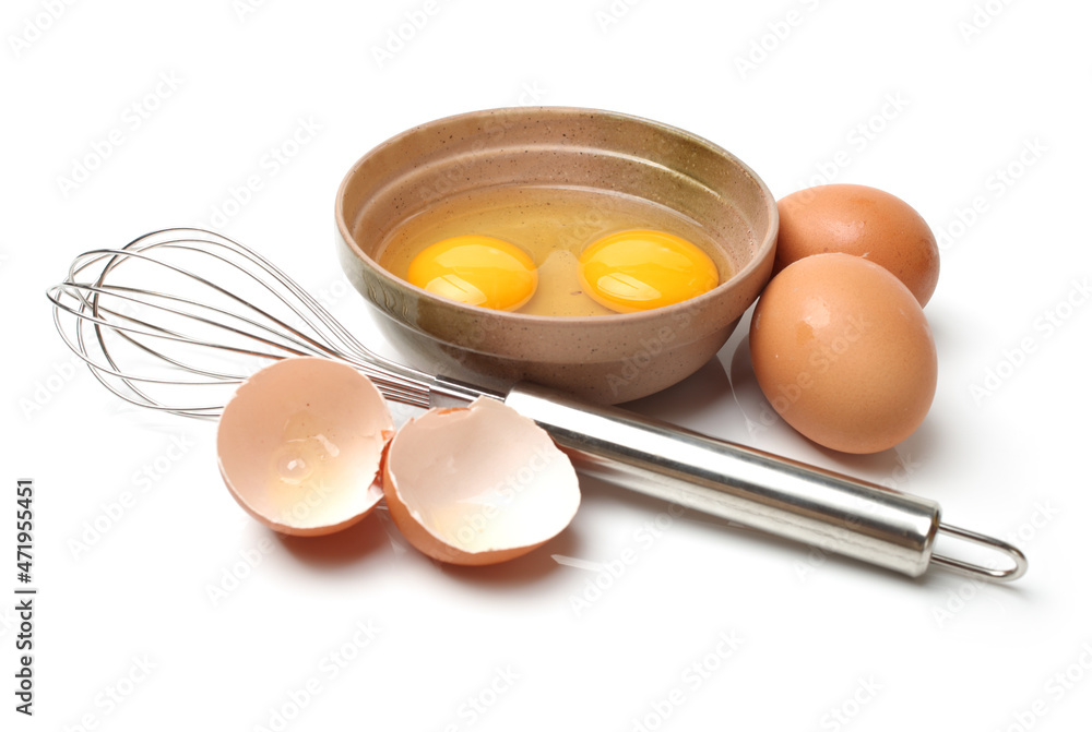 Wire whisk and brown eggs on white background Wire whisk and brown eggs on white background