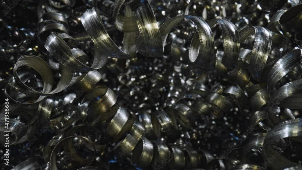 Macro shot of the metal shavings, which can be iron, aluminum or steel. Metal shavings background. Curly metallic spirals, industrial recycling. Close up twisted spiral steel shavings. Slow motion. Macro shot of the metal shavings, which can be iron, aluminum or steel. Metal shavings background. Curly metallic spirals, industrial recycling. Close up twisted spiral steel shavings. Slow motion.