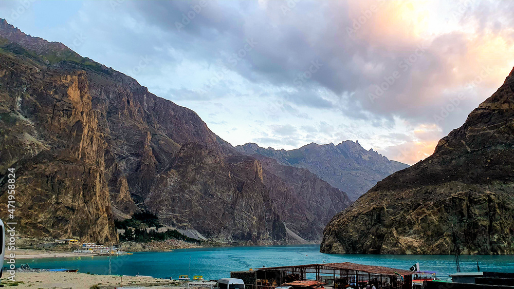 Attabad lake a renown lake in Hunza Valley Pakistan with boat in the water and beautiful mountains covered with clouds