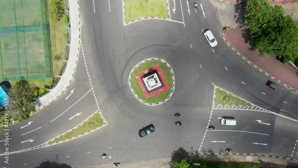 Aerial top down view spinning over busy roundabout with tuk tuks