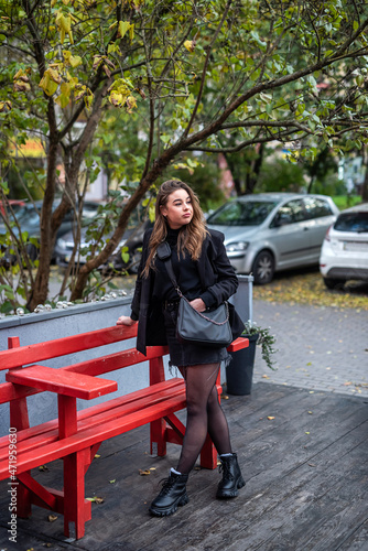 tall beautiful girl in black stands on the streets of the city in which she arrived in autumn