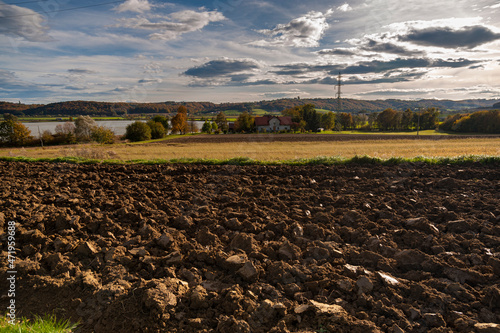 A plowed field with a farm in the background, Prekmurje, Slovenia photo