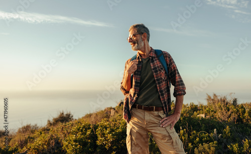 Fotografie, Obraz Carefree hiker looking away cheerfully on a hilltop