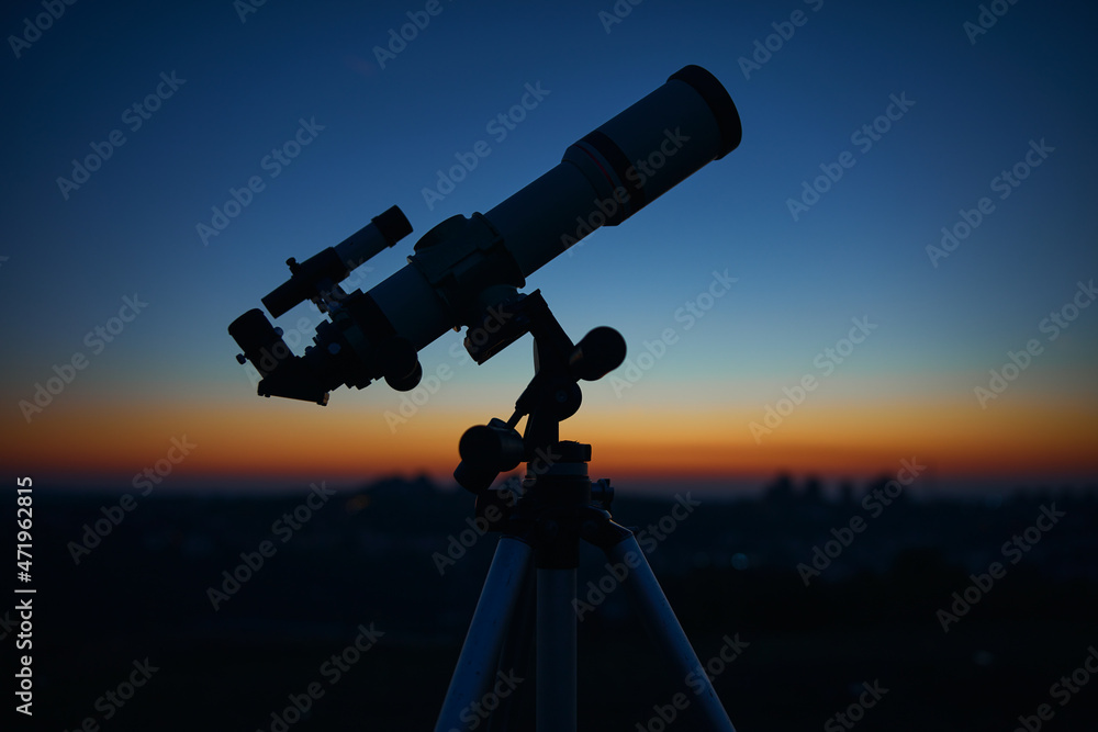 Astronomical telescope under a twilight sky ready for stargazing.