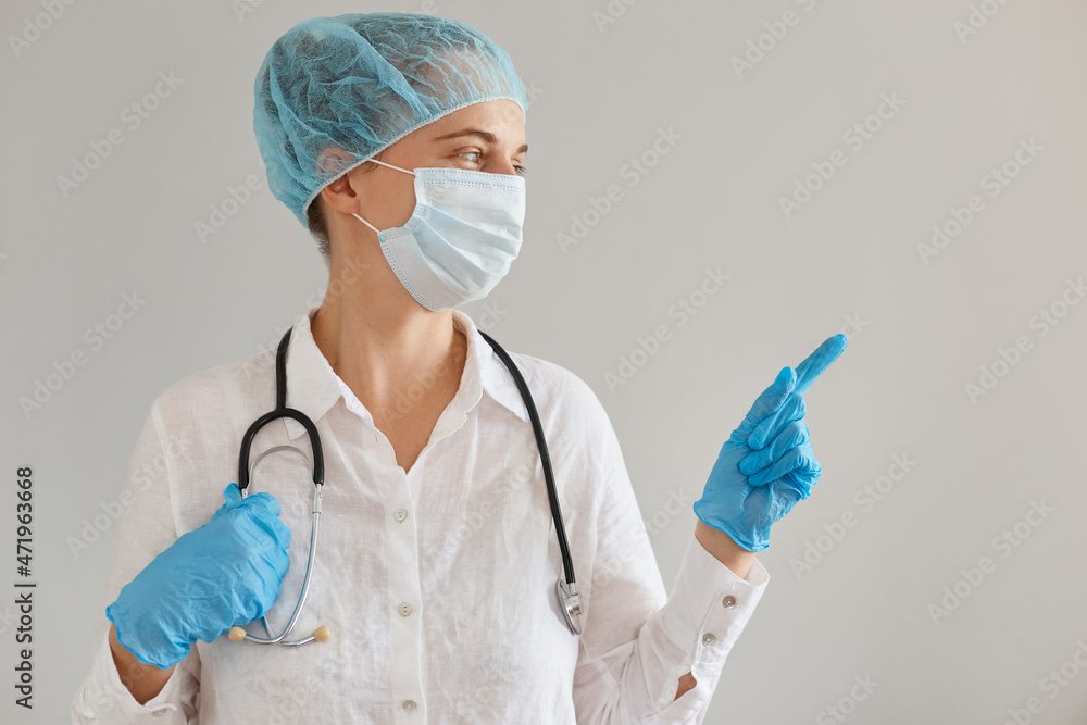 Portrait of female doctor wearing medical cap, gloves, surgical mask