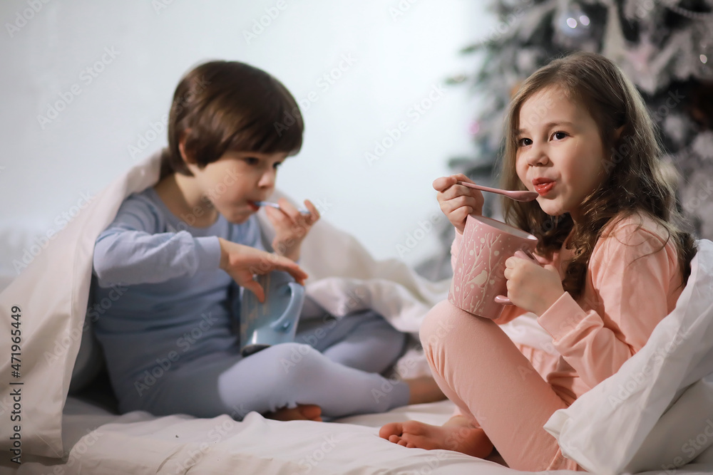 A family with children having fun on the bed under the covers during the Christmas holidays. A family with children having fun on the bed under the covers during the Christmas holidays.