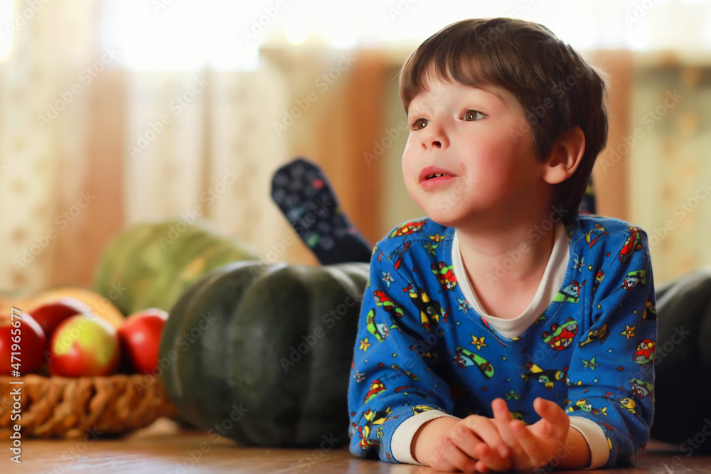 Fototapeta premium Little child choose a pumpkin at autumn. Child sitting on giant pumpkin. Pumpkin is traditional vegetable used on American holidays - Halloween and Thanksgiving Day.