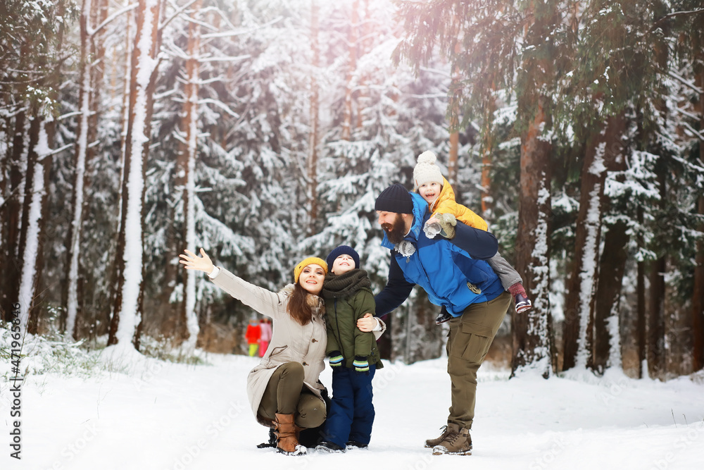 Happy family playing and laughing in winter outdoors in the snow. City park winter day.