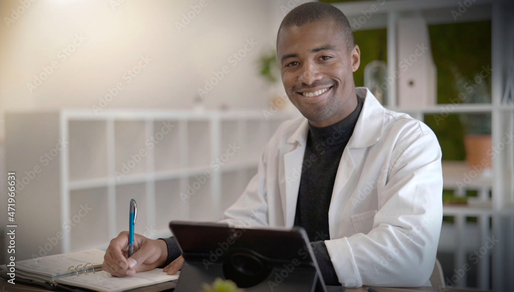 portrait of an African doctor working on his tablet in a meeting room in a hospital portrait of an African doctor working on his tablet in a meeting room in a hospital