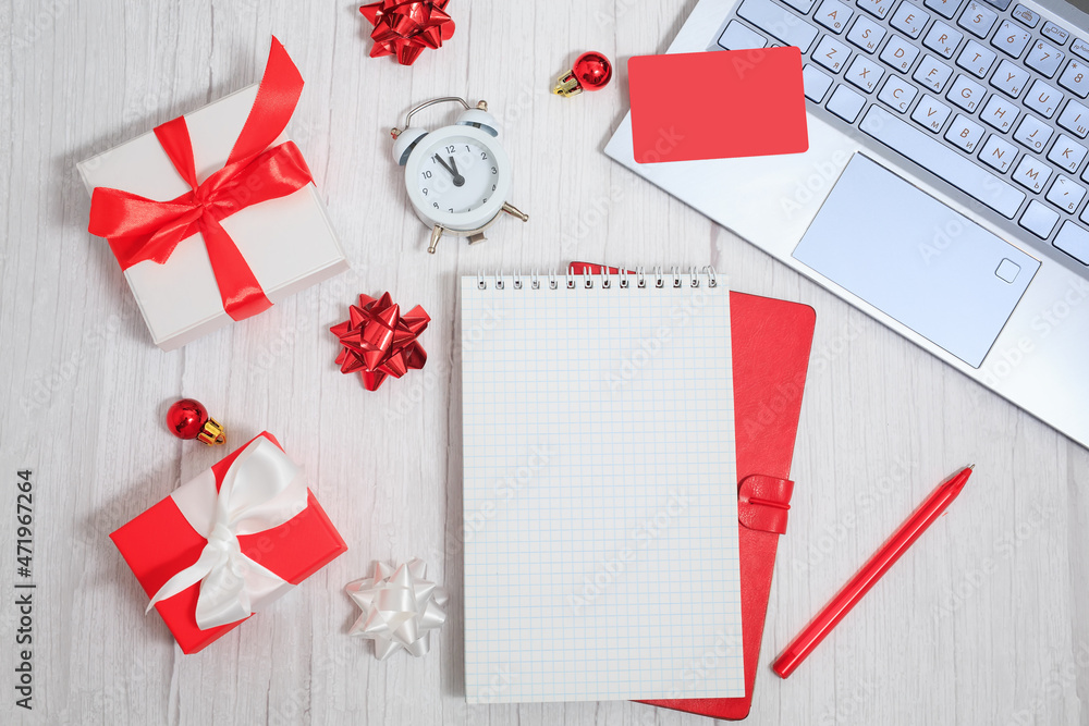 Christmas composition. Notepad with goals for 2022. Laptop, notebook, pen, gift boxes, alarm, balls and stars. Concept business Christmas. Goals and objectives Christmas composition. Notepad with goals for 2022. Laptop, notebook, pen, gift boxes, alarm, balls and stars. Concept business Christmas. Goals and objectives