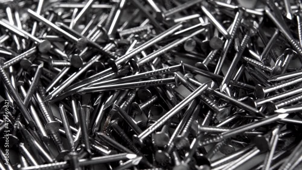 Steel thin small nails. Macro. Slow rotation. Industrial tool concept Steel thin small nails. Macro. Slow rotation. Industrial tool concept