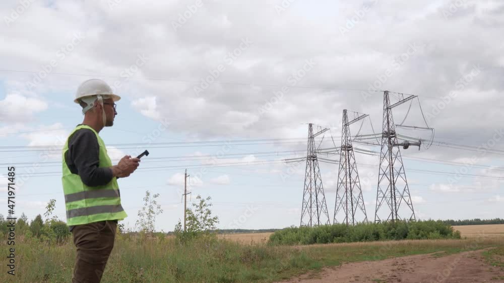 An electrical engineer forcing a drone To inspect high voltage poles before starting a project. An electrical engineer forcing a drone To inspect high voltage poles before starting a project.