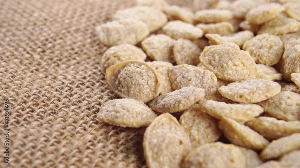 Crispy dry quinoa flakes on a rustic coarse burlap. Healthy breakfast concept. Macro. Rotation Crispy dry quinoa flakes on a rustic coarse burlap. Healthy breakfast concept. Macro. Rotation